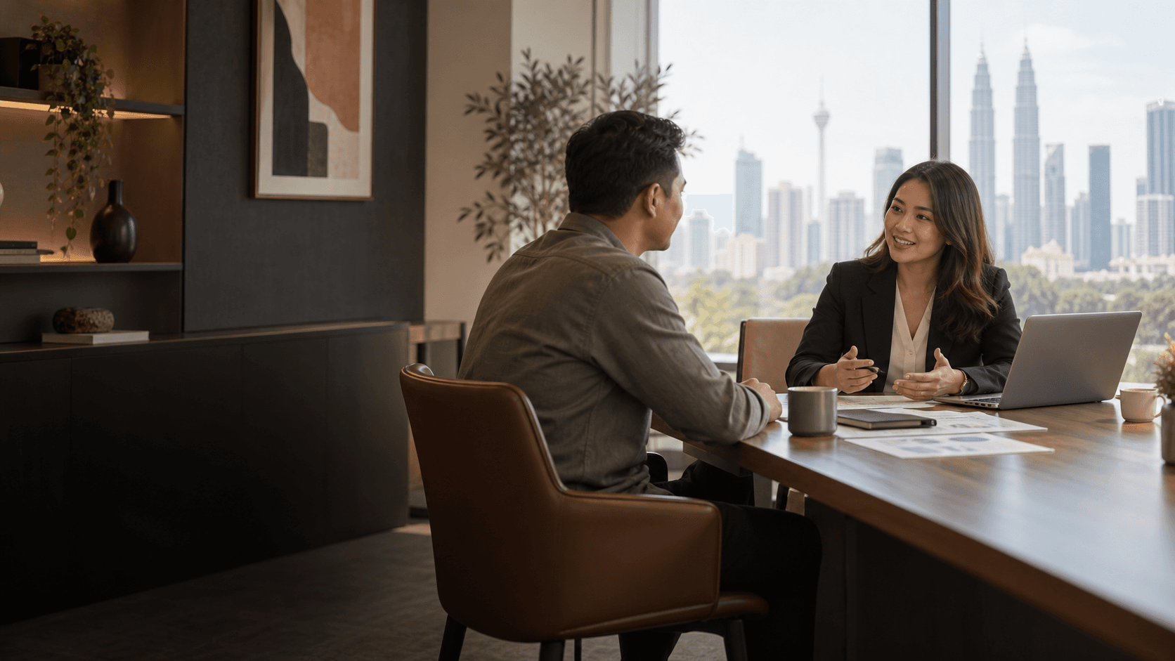A Malaysian business owner meeting an accounting adviser in a Kuala Lumpur office