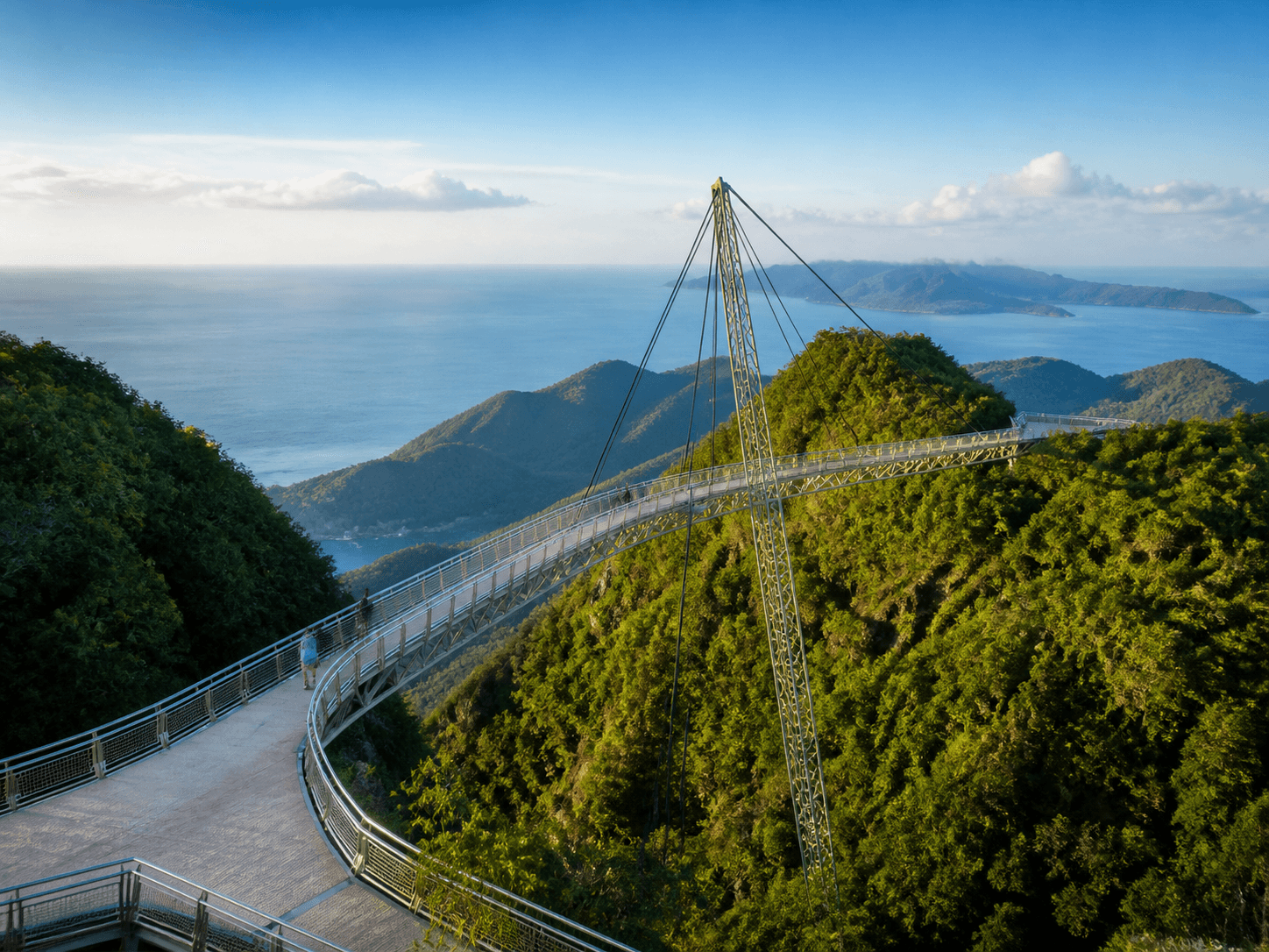 Curved sky bridge above rainforest and sea